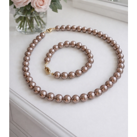 Klasyczny zestaw z pudrowo-różowych pereł – naszyjnik i bransoletka jako elegancki detal stylizacji.