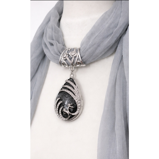 Chusta z ozdobnym wisiorem – biżuteryjny detal, który nadaje stylizacji lekkości i charakteru.