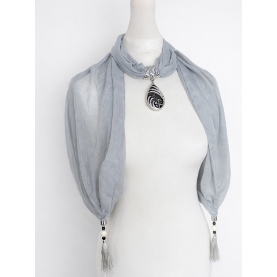 Chusta z ozdobnym wisiorem – biżuteryjny detal, który nadaje stylizacji lekkości i charakteru.