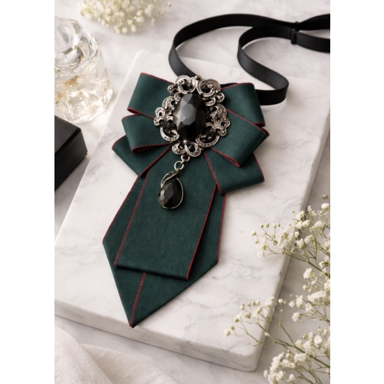 Broszka-krawatka z biżuteryjną aplikacją – szlachetna elegancja w głębokiej, butelkowej zieleni.