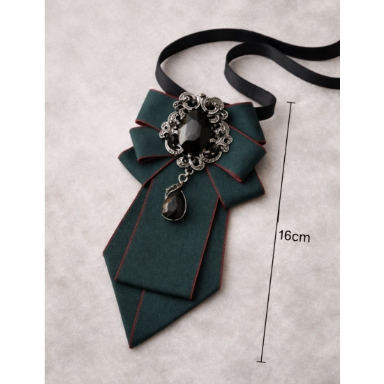 Broszka-krawatka z biżuteryjną aplikacją – szlachetna elegancja w głębokiej, butelkowej zieleni.