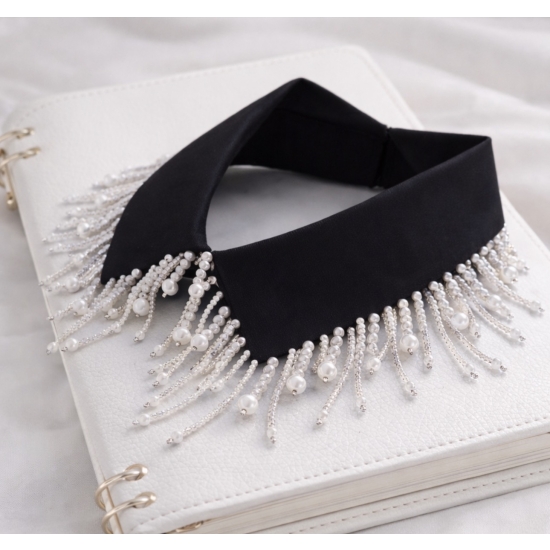 Czarny biżuteryjny kołnierzyk ze srebrnymi i białymi dodatkami – elegancki, efektowny akcent stylizacji.