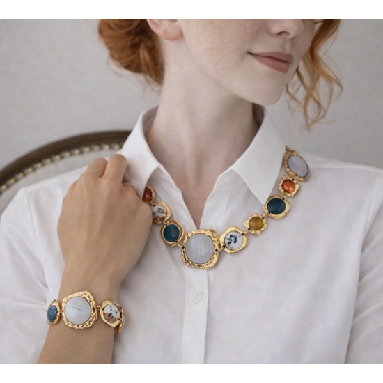 Elegancki komplet biżuterii w złotym odcieniu z dekoracyjnymi kamieniami – naszyjnik i bransoletka.