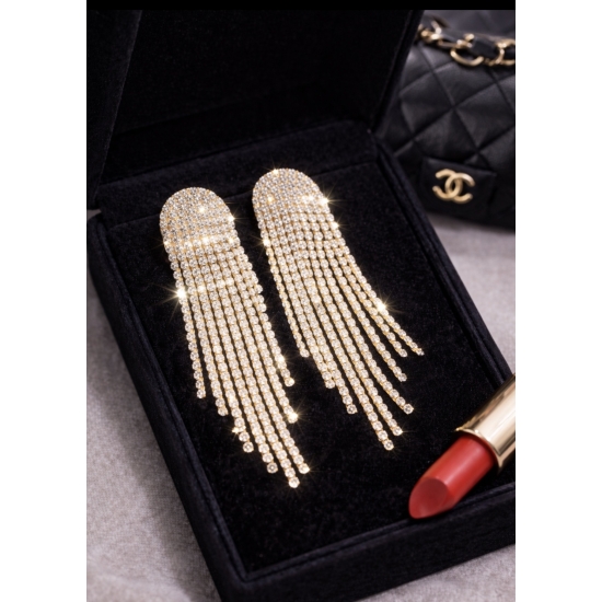 Efektowne, długie kolczyki w złotym odcieniu z kaskadą lśniących kryształków – biżuteria glamour stworzona, by przyciągać spojrzenia.