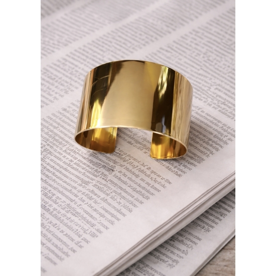 Elegancka, szeroka bransoleta w kolorze złota – minimalistyczny dodatek, który podkreśla kobiecą klasę i styl.