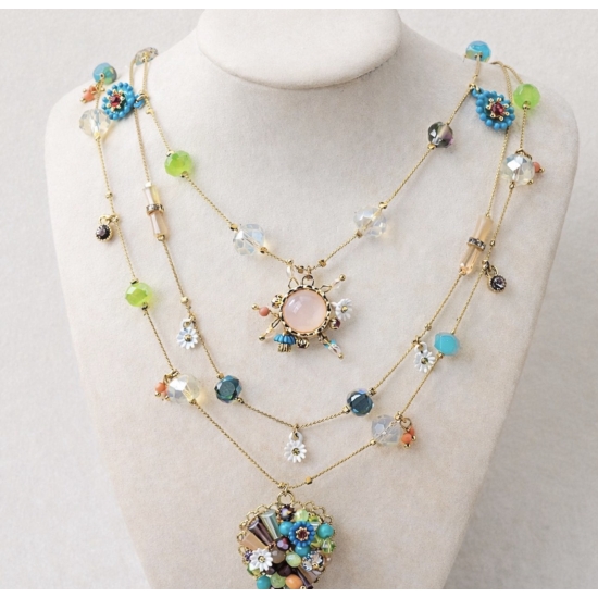 Efektowny, wielowarstwowy naszyjnik z kolorowymi kamieniami i zawieszkami.