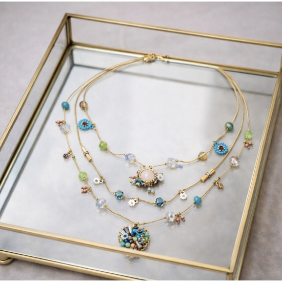 Efektowny, wielowarstwowy naszyjnik z kolorowymi kamieniami i zawieszkami.