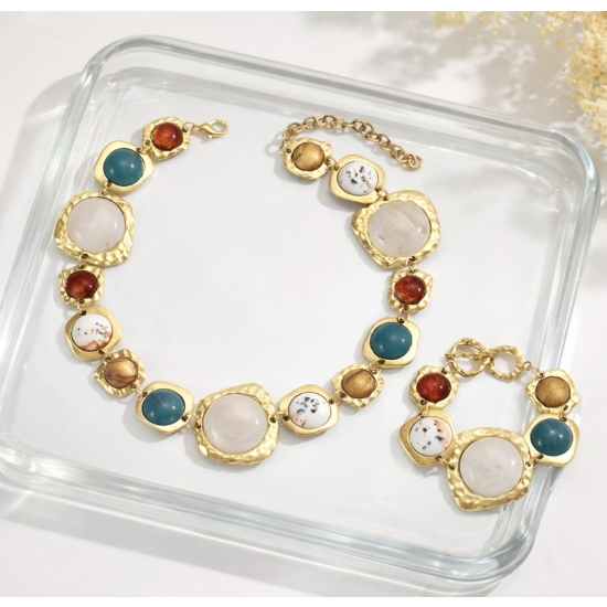 Elegancki komplet biżuterii w złotym odcieniu z dekoracyjnymi kamieniami – naszyjnik i bransoletka.