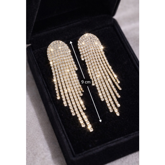 Efektowne, długie kolczyki w złotym odcieniu z kaskadą lśniących kryształków – biżuteria glamour stworzona, by przyciągać spojrzenia.