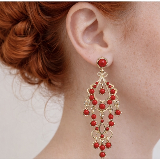 Eleganckie, długie kolczyki w złotym kolorze z czerwonymi kamieniami – biżuteria w stylu glamour, która przyciąga spojrzenia.