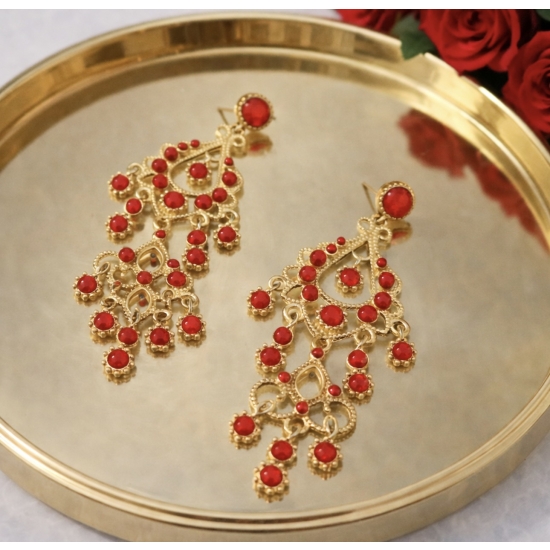 Eleganckie, długie kolczyki w złotym kolorze z czerwonymi kamieniami – biżuteria w stylu glamour, która przyciąga spojrzenia.