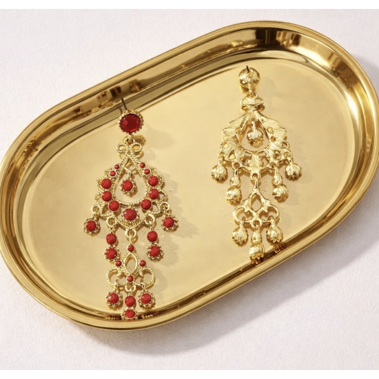 Eleganckie, długie kolczyki w złotym kolorze z czerwonymi kamieniami – biżuteria w stylu glamour, która przyciąga spojrzenia.