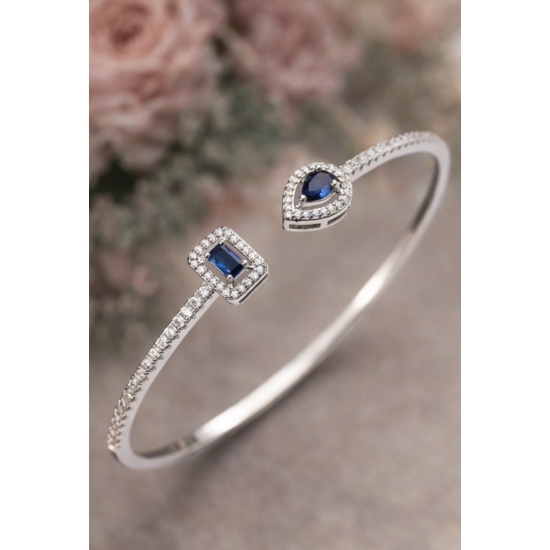 Sztywna bransoletka w kolorze srebrnym z niebieskimi kamieniami – elegancka i ponadczasowa.