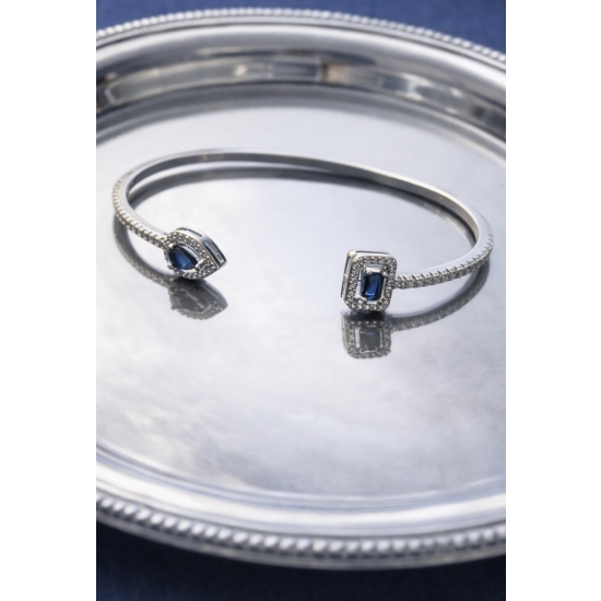 Sztywna bransoletka w kolorze srebrnym z niebieskimi kamieniami – elegancka i ponadczasowa.