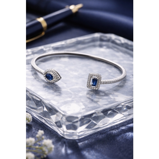 Sztywna bransoletka w kolorze srebrnym z niebieskimi kamieniami – elegancka i ponadczasowa.