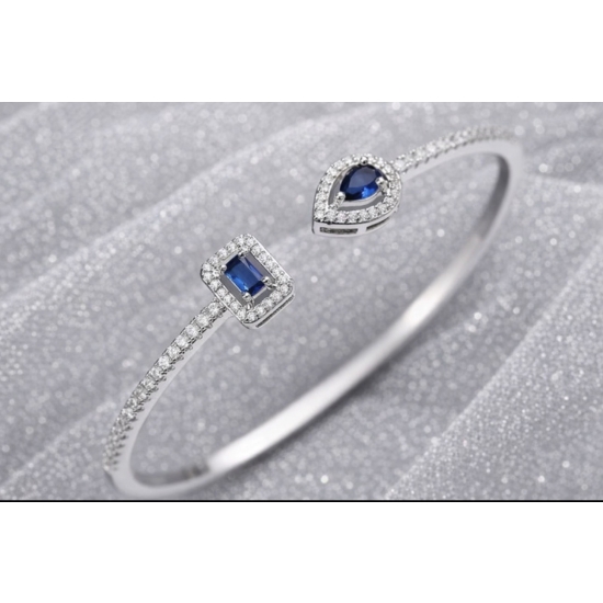 Sztywna bransoletka w kolorze srebrnym z niebieskimi kamieniami – elegancka i ponadczasowa.