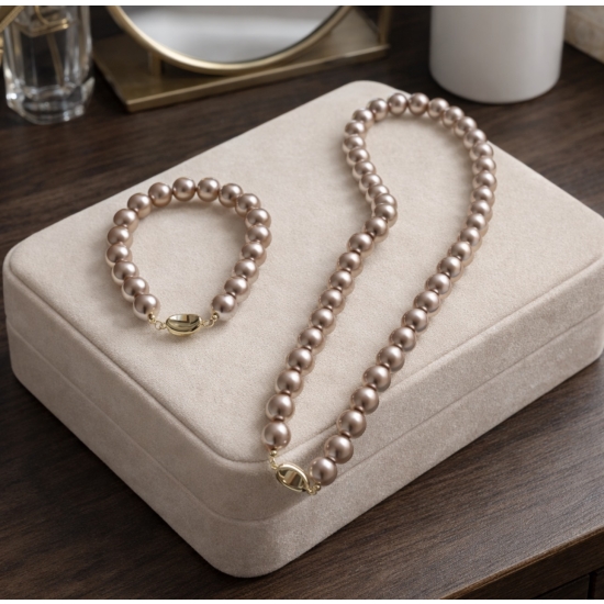 Klasyczny zestaw z pudrowo-różowych pereł – naszyjnik i bransoletka jako elegancki detal stylizacji.