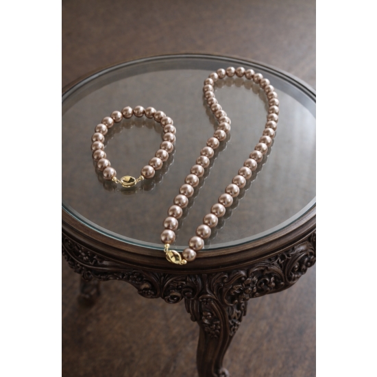 Klasyczny zestaw z pudrowo-różowych pereł – naszyjnik i bransoletka jako elegancki detal stylizacji.