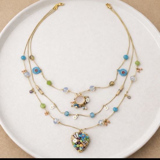 Efektowny, wielowarstwowy naszyjnik z kolorowymi kamieniami i zawieszkami.